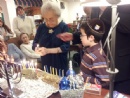 Chanukah: Smile on Seniors!: Levi lighting menorah with Ruth Moskowitz